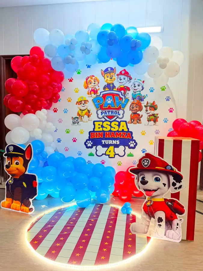 Paw Patrol themed birthday backdrop with blue, red and white balloons and character cut-outs