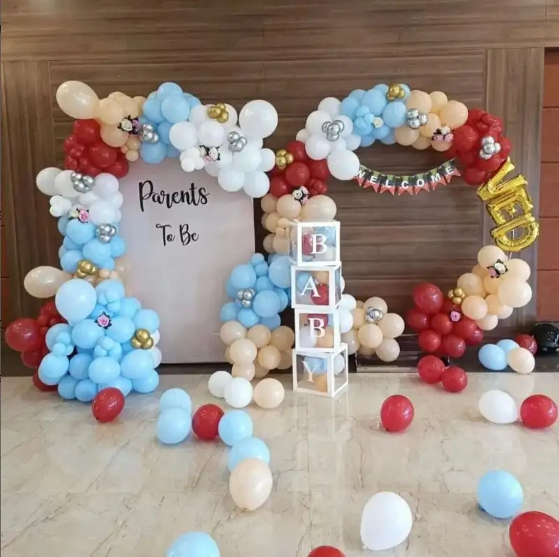 Blue, white and gold balloon garland with letter blocks and gift boxes on the floor