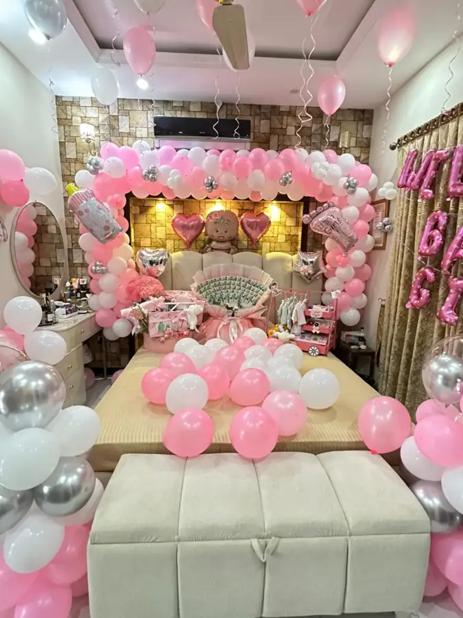 Bedroom decorated with pink and silver balloons and a floral backdrop