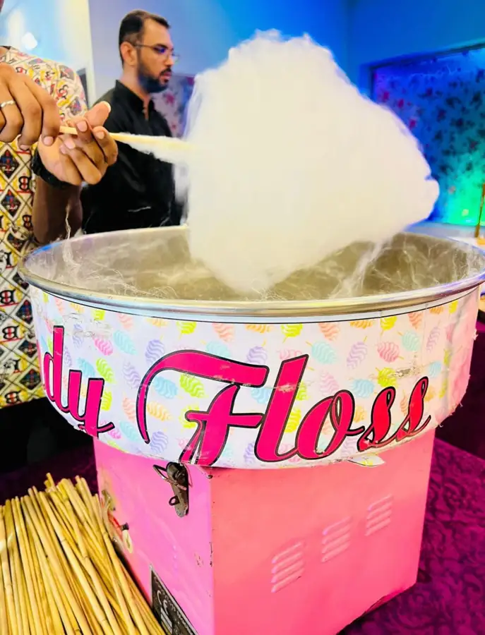 Cotton candy being spun in a pink candy floss machine