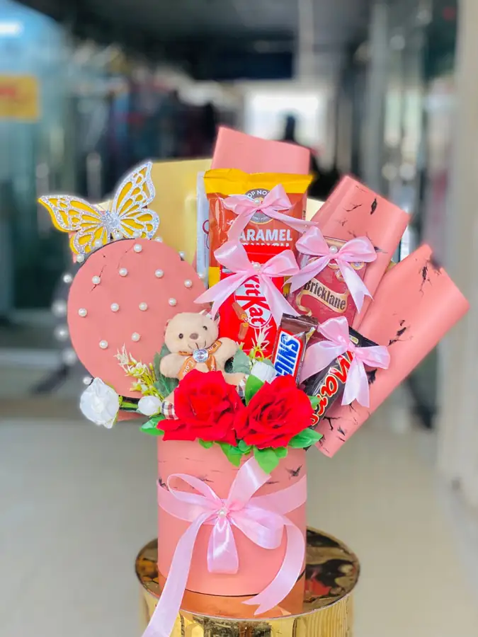 Pink gift bouquet with roses, chocolates and a teddy bear