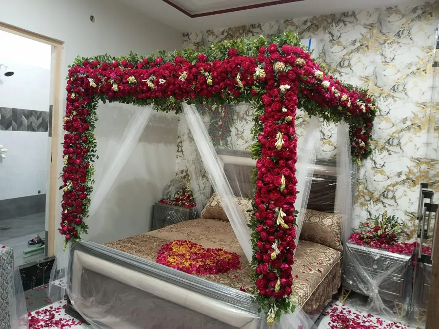 Bedroom with a red flower frame over the bed and white drapes