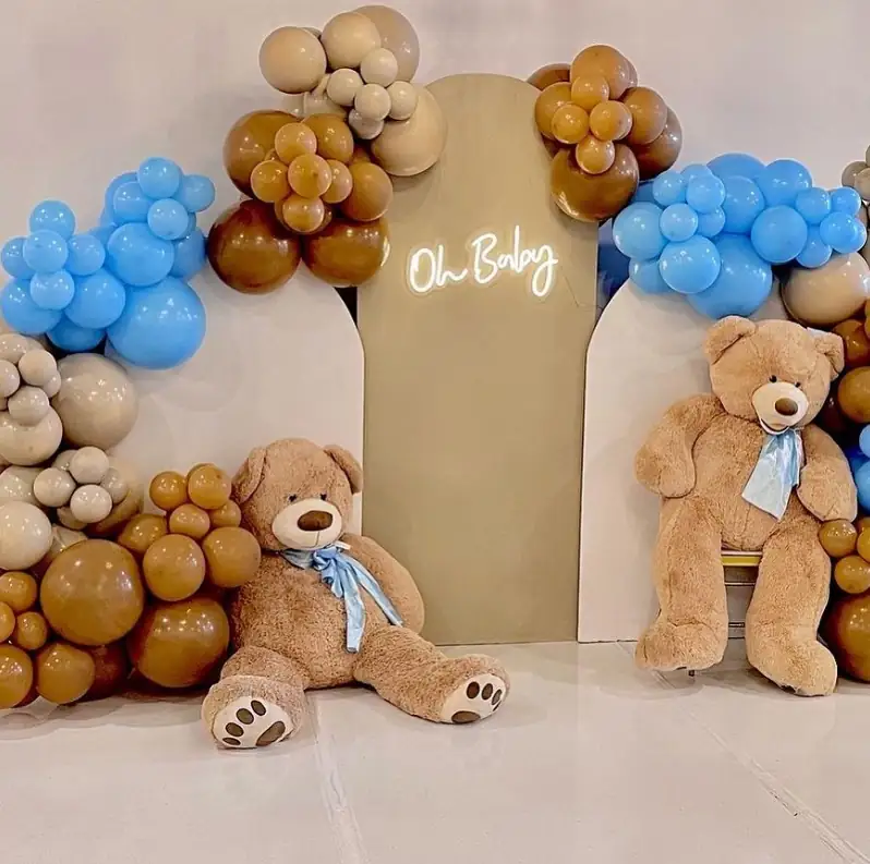 Baby shower setup with brown and blue balloons, large teddy bears and an Oh Baby neon sign