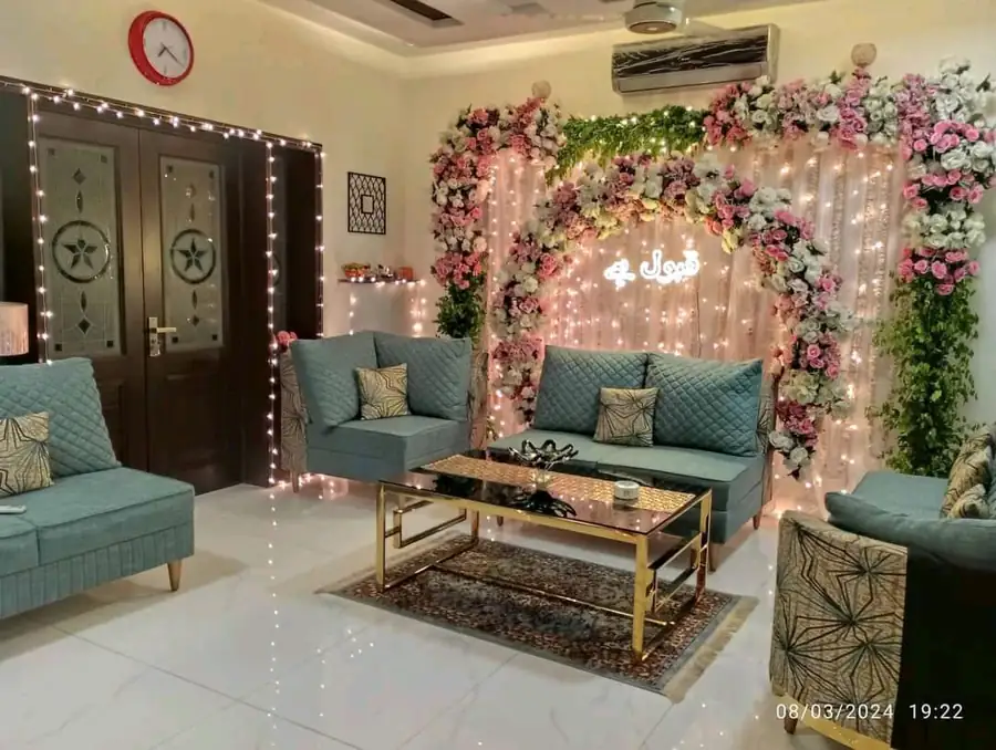 Home nikah setup with a flower backdrop, fairy lights and a seating area