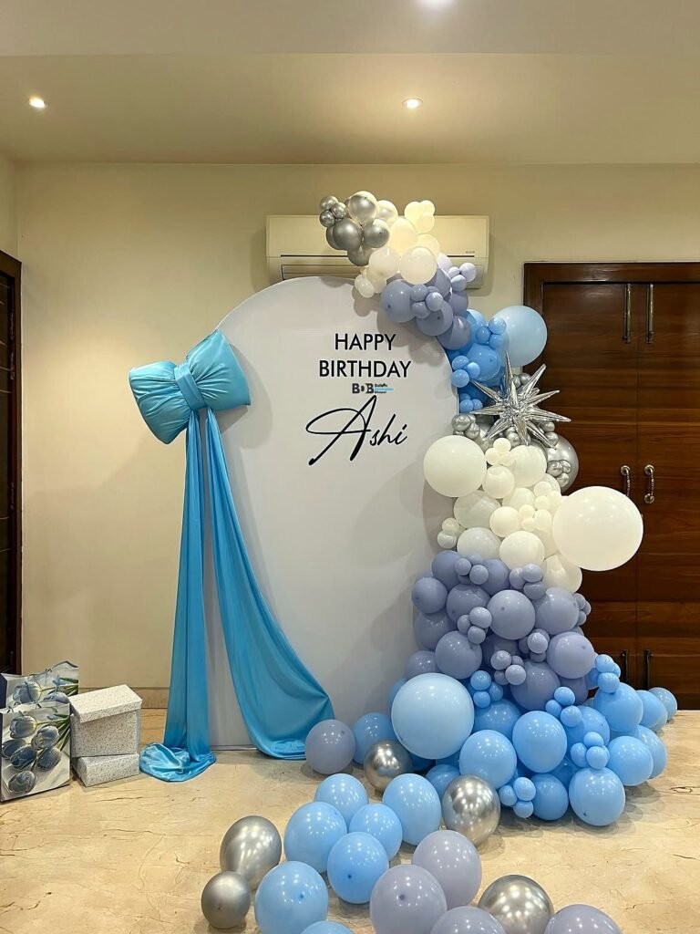 Light blue bow backdrop with a silver and blue balloon garland