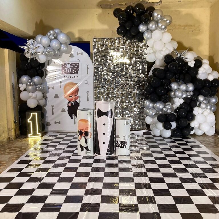 Boss Baby birthday with black, white and silver balloons and a sequin wall