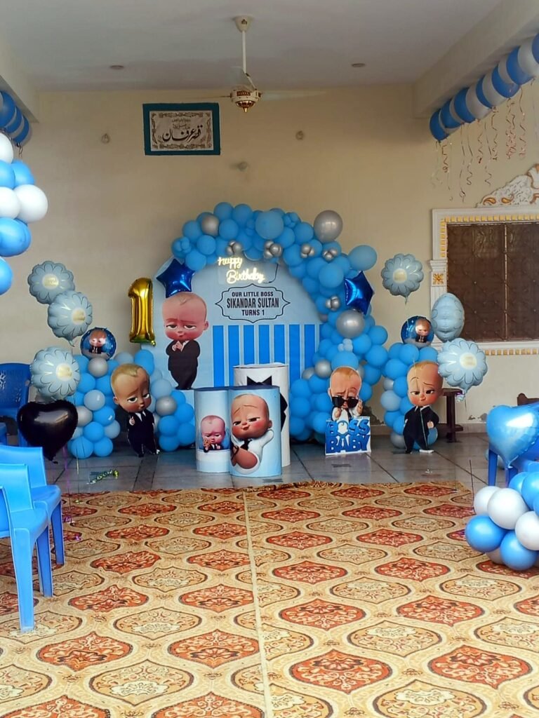 Boss Baby theme first birthday with a blue balloon arch and number one balloon