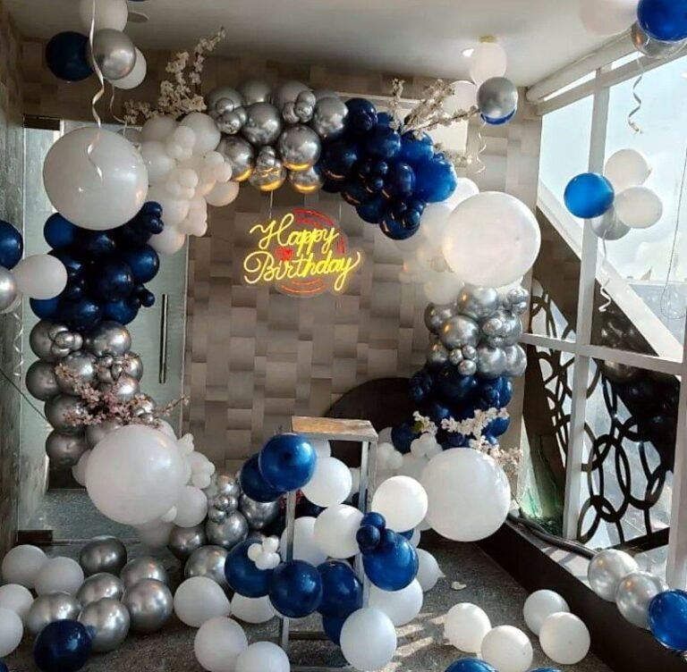 Navy, silver and white organic balloon arch with a Happy Birthday neon sign