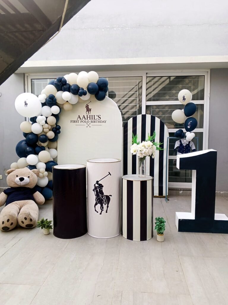 Navy, white and silver first birthday backdrop with a number one, striped stands and teddy bears