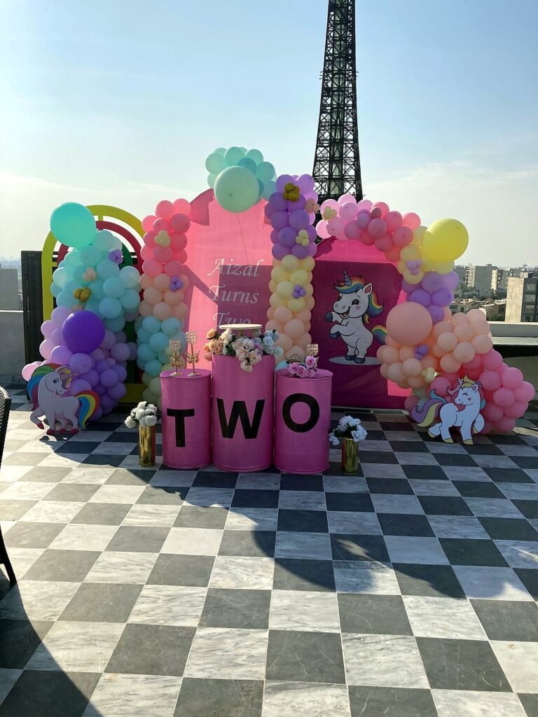 Paris themed second birthday setup with an Eiffel Tower, pastel balloons and a TWO sign
