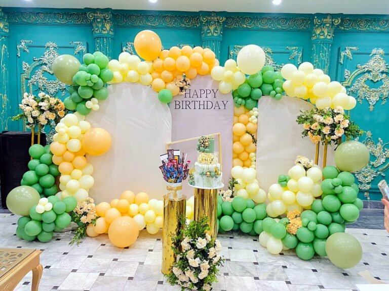 Pastel green, yellow and white balloon frame backdrop for a birthday