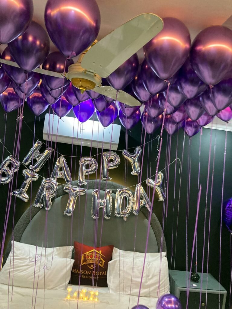 Birthday room with a purple balloon ceiling and silver Happy Birthday letters