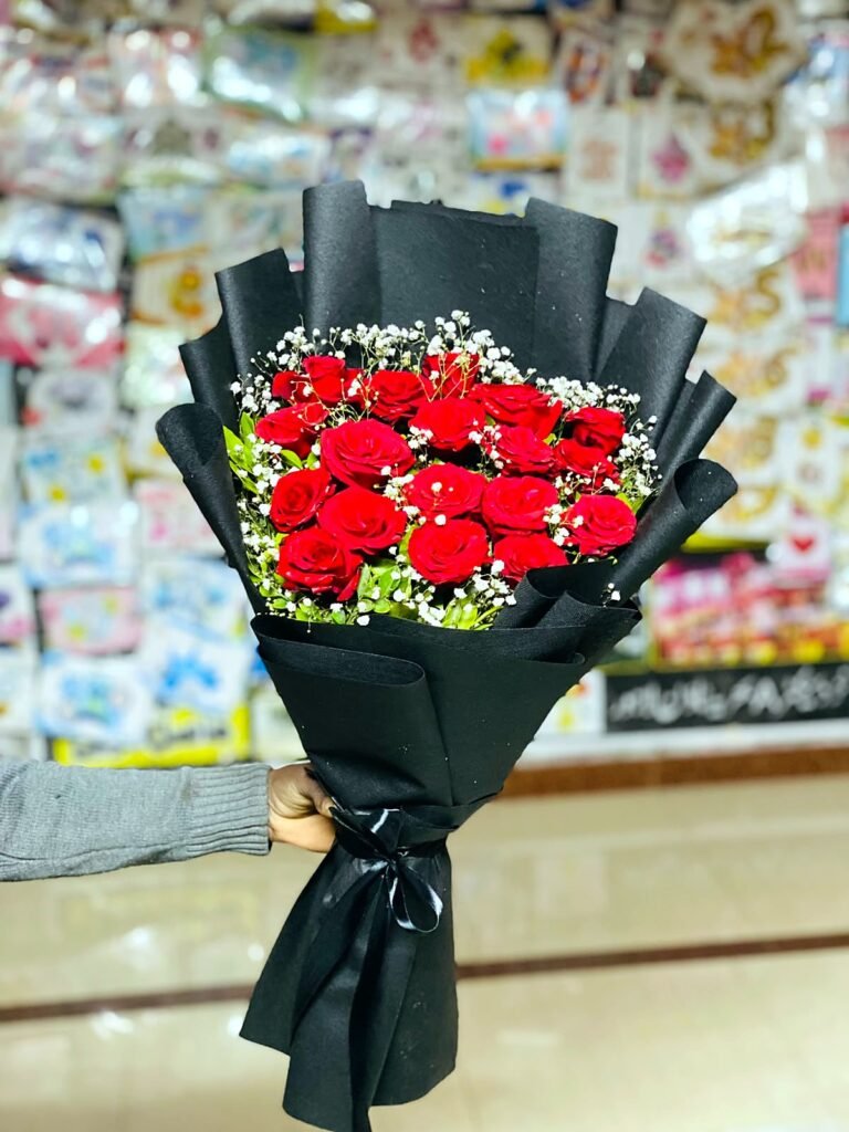 Red roses with baby's breath in black wrapping