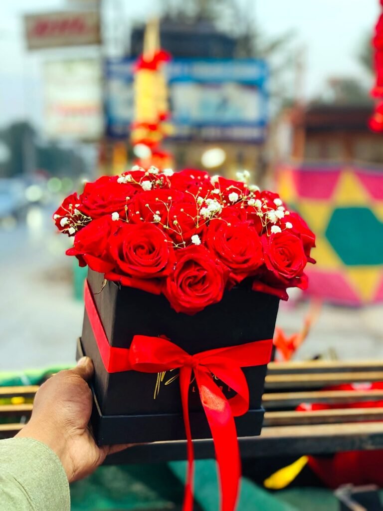 Box of red roses with a red ribbon