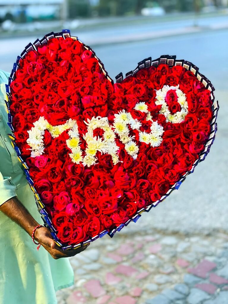 Heart shaped red rose arrangement with a name spelled in white flowers