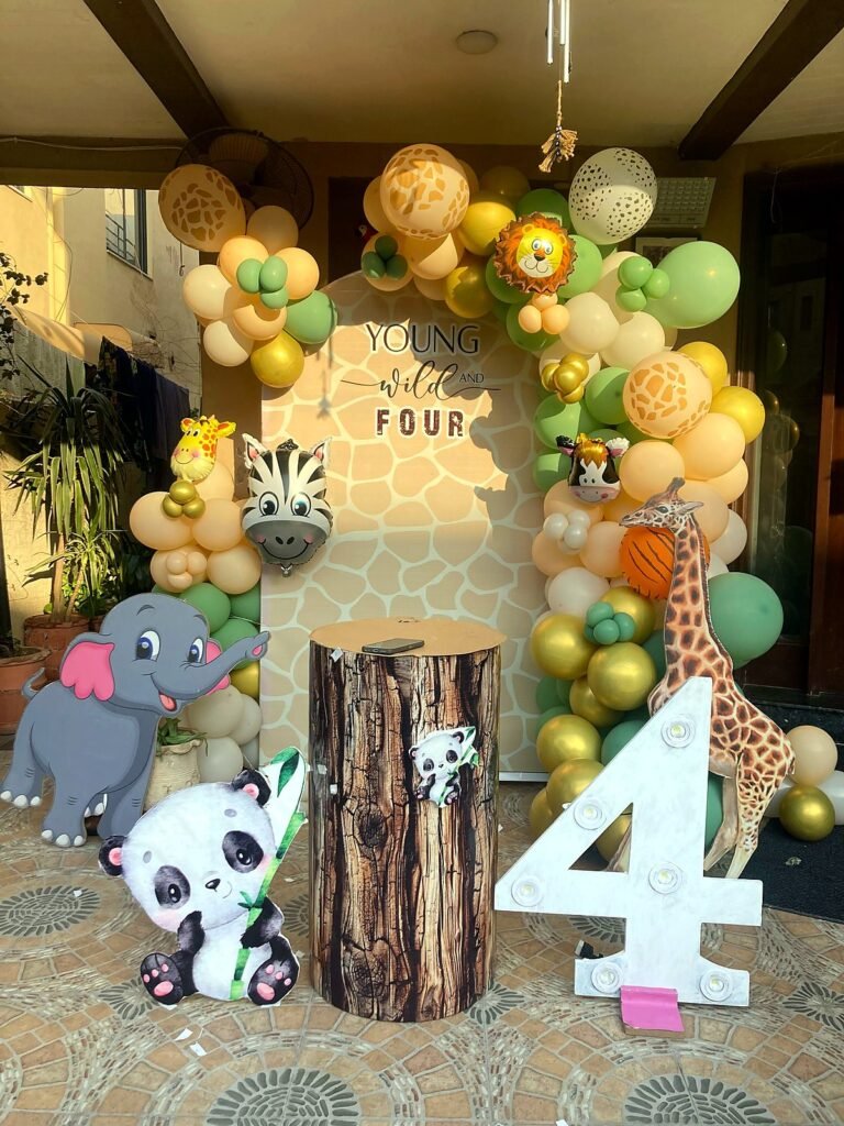 Safari themed fourth birthday balloon arch with animal cut-outs and a number four